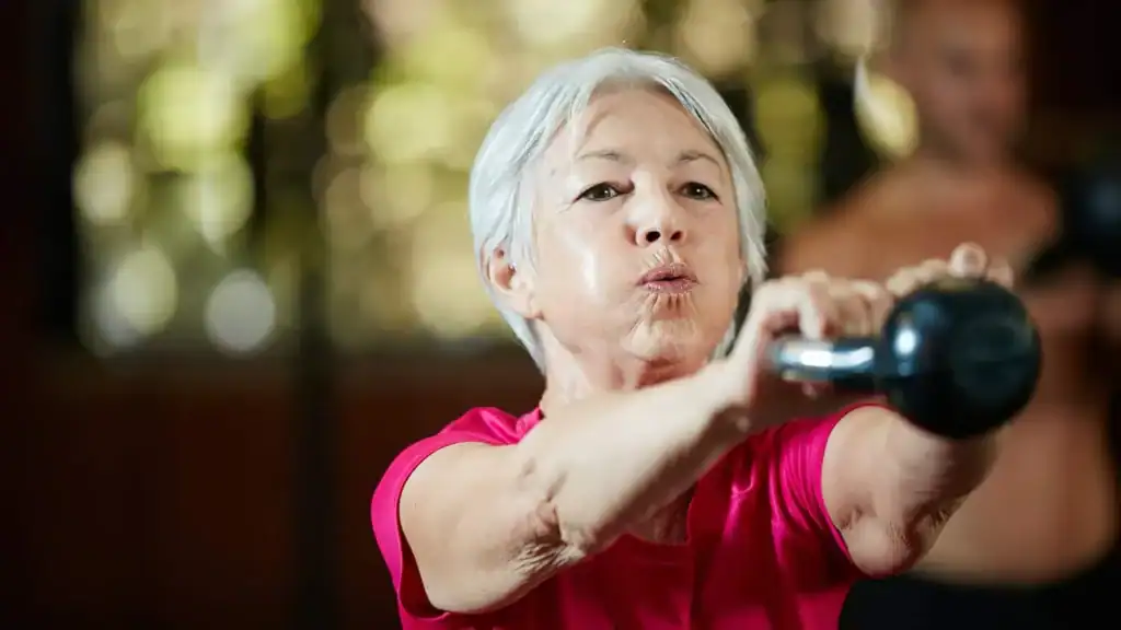 Older woman doing weight training Aldershot to help her strength and longevity 