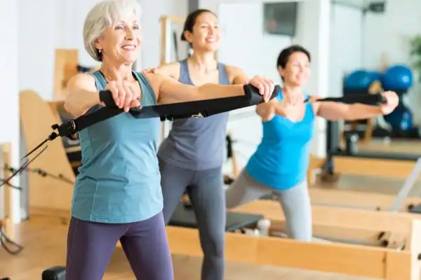 older woman doing weight training Aldershot and resistance in the gym to tone upper arms