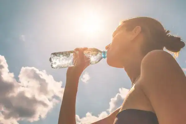Image of woman drinking water to hydrate Aldershot after run.